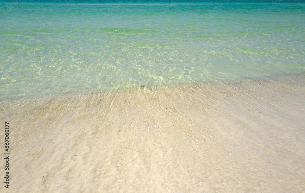 Wave of the sea on the sand beach. Sand beach with blue ocean and cloudscape background. Sea panorama. Tropical ocean and beach.
