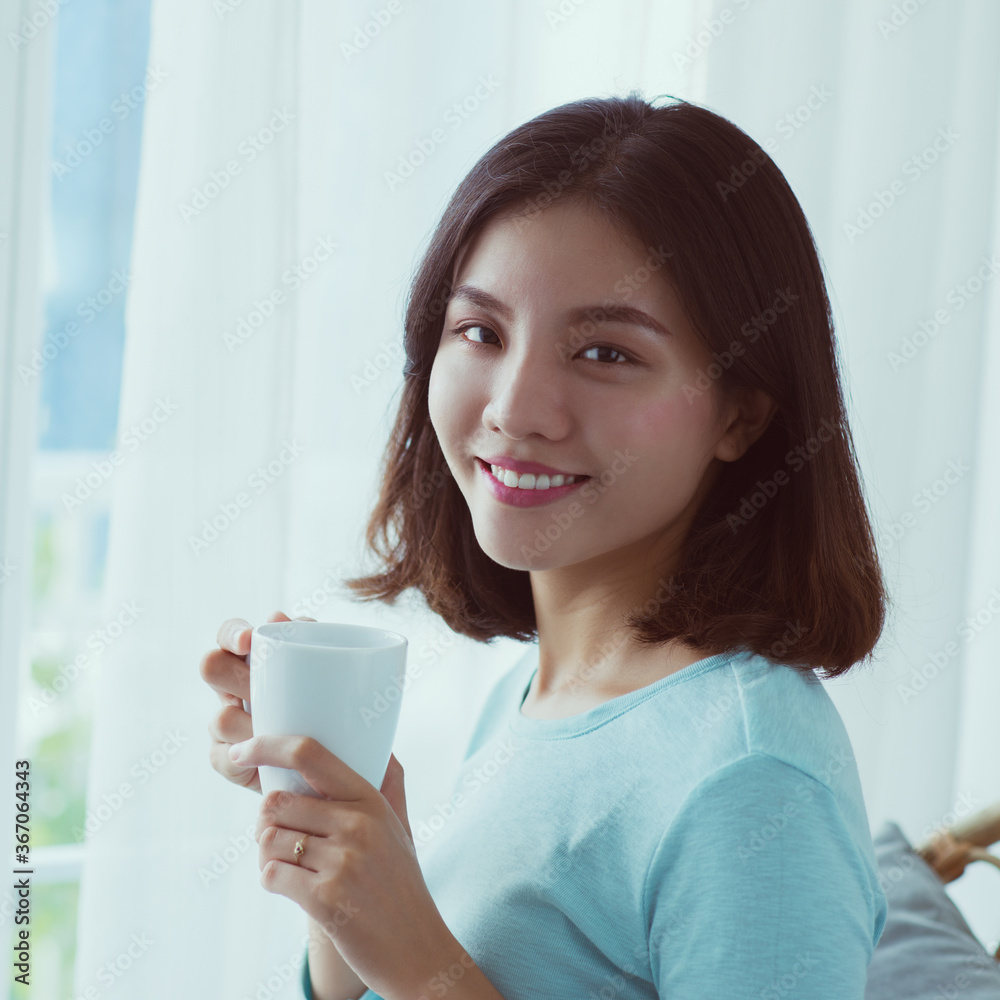 Portrait of young Asian woman drinking coffee behind the window. Portrait of young Asian woman drinking coffee behind the window.