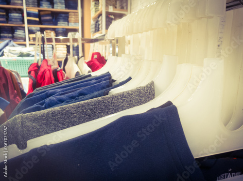 T shirts in hangers are aligned in an array inside a textile showroom. © ASHWIN