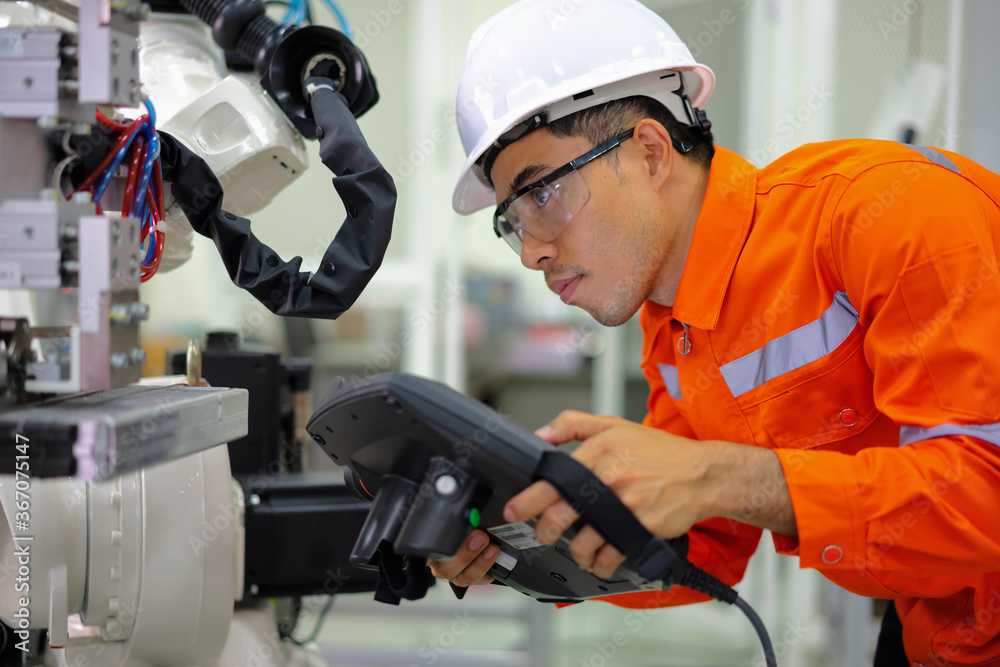 Smart factort concept: An engineer use handheld controller setting industrial robot in productionplant. Smart factort concept: An engineer use handheld controller setting industrial robot in productionplant.