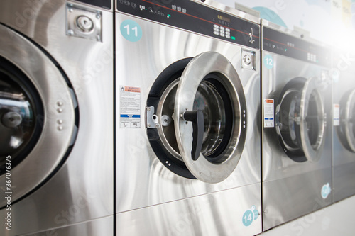 Close-Up multiple Industrial Washing Machines in Laundry shop, Washing with hot and cold water keeps clothes clean and trendy.