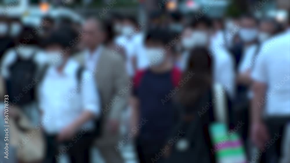 TOKYO, JAPAN - JUL 2020 : Crowd of people at the street near Shinjuku station in rush hour. Commuters wearing surgical mask to protect from Coronavirus (COVID-19) in hot summer. Blurred slow motion. TOKYO, JAPAN - JUL 2020 : Crowd of people at the street near Shinjuku station in rush hour. Commuters wearing surgical mask to protect from Coronavirus (COVID-19) in hot summer. Blurred slow motion.