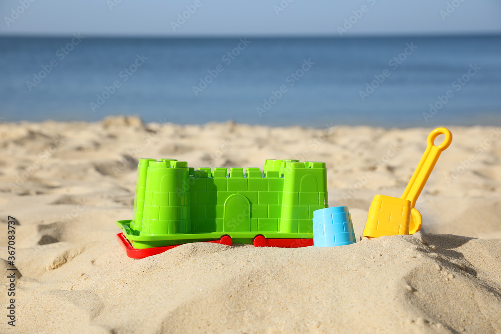 Child plastic toys on sandy beach at sunny day Child plastic toys on sandy beach at sunny day