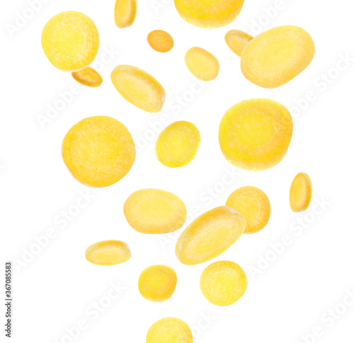 Yellow carrot slices falling on white background