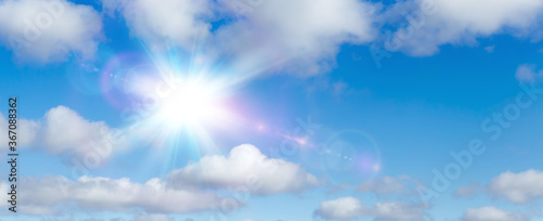 Natural summer background, sun over blue sky with white clouds.