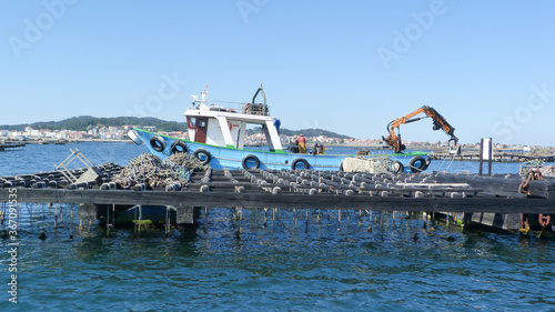 Foto Barco pesquero mejillonero  trabajando en la batea donde se cultiva el mejillón en la ría de Vígo (España)
