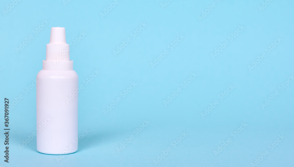 Nasal spray, drops in white bottle. Isolated on blue background, copy space template, banner. Nasal spray, drops in white bottle. Isolated on blue background, copy space template, banner.