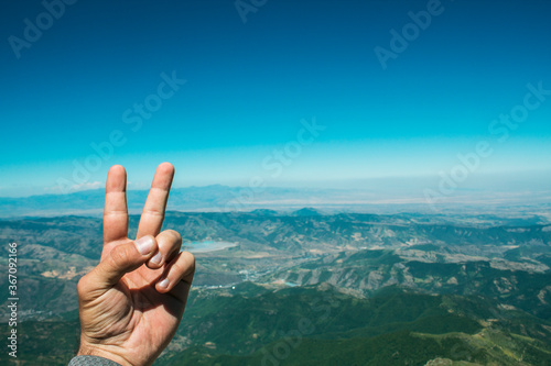 shows the sign of peace on the top of the mountain