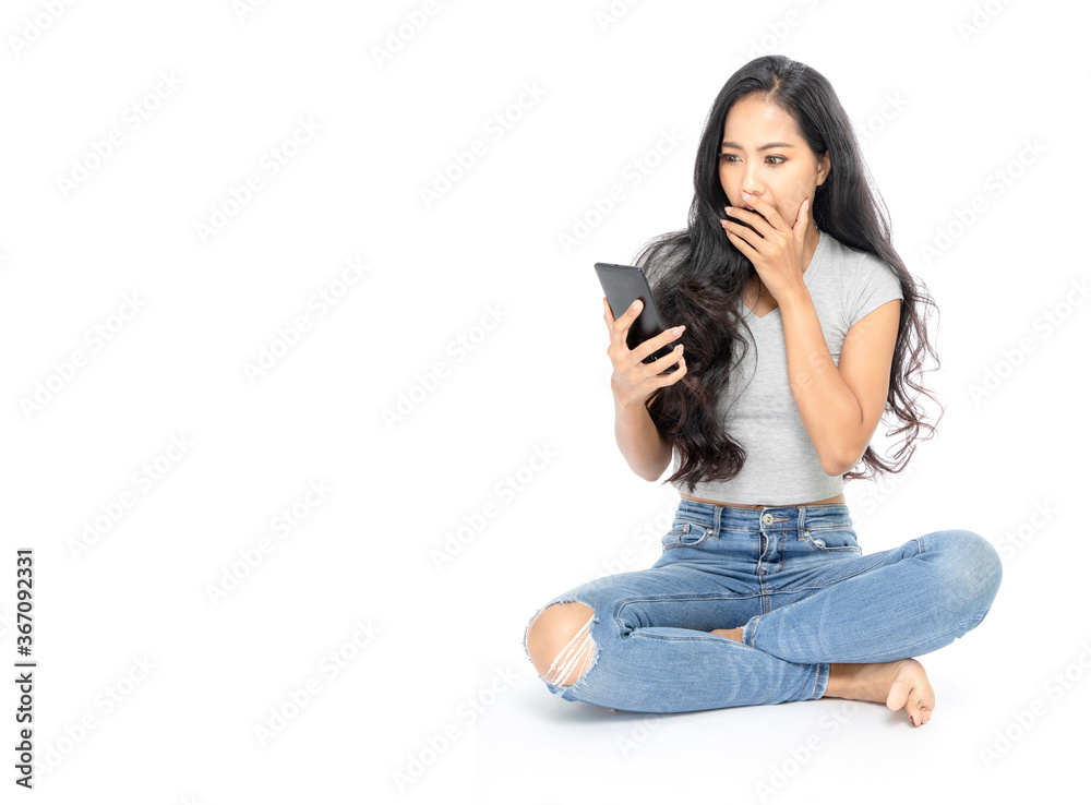 isolated woman sits and show a smartphone in hand her surprised isolated woman sits and show a smartphone in hand her surprised
