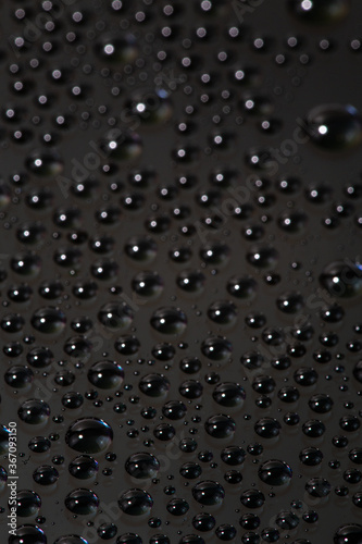 many small water drops on the black surface of cellphone hydriphobic coated glass screen photo