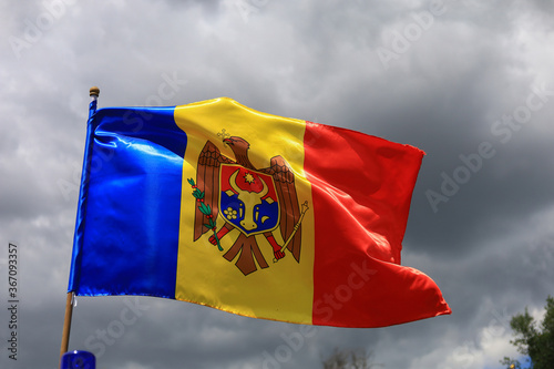 The official flag of the state of the Republic of Moldova against the sky