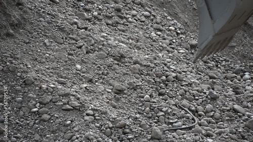 Close up excavator digging sand pebbles from the river. Heavy industry and environment. Ecological disaster. Water pollution. Machine dredging river canal. Dam building. Slow motion, static shot