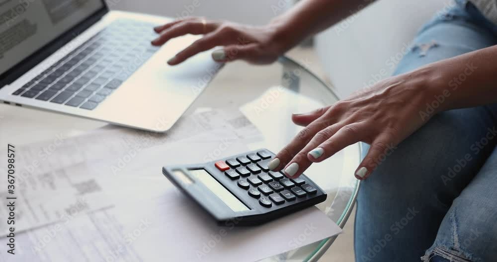 Close up view unrecognizable female hands using modern wireless laptop and calculator manage finances personal expenses make e-payment use e-bank app. Accountant do telecommute work from home concept Close up view unrecognizable female hands using modern wireless laptop and calculator manage finances personal expenses make e-payment use e-bank app. Accountant do telecommute work from home concept