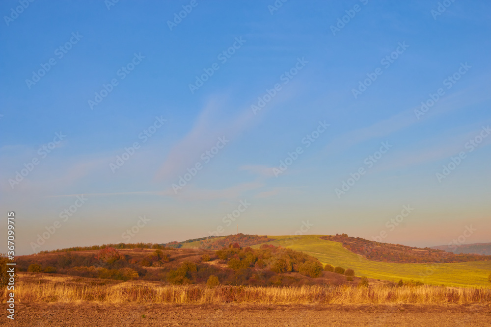 Obraz premium autumn landscape at sunset,late autumn with fog at sunset on a background of mountains