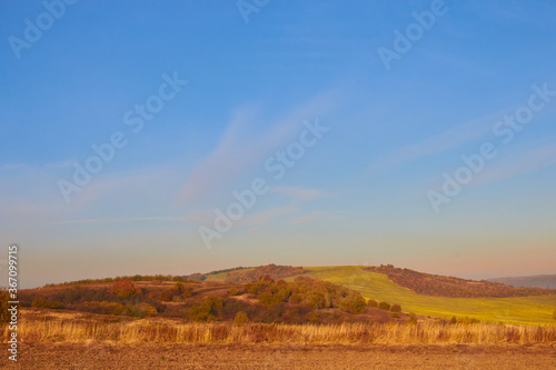 autumn landscape at sunset,late autumn with fog at sunset on a background of mountains