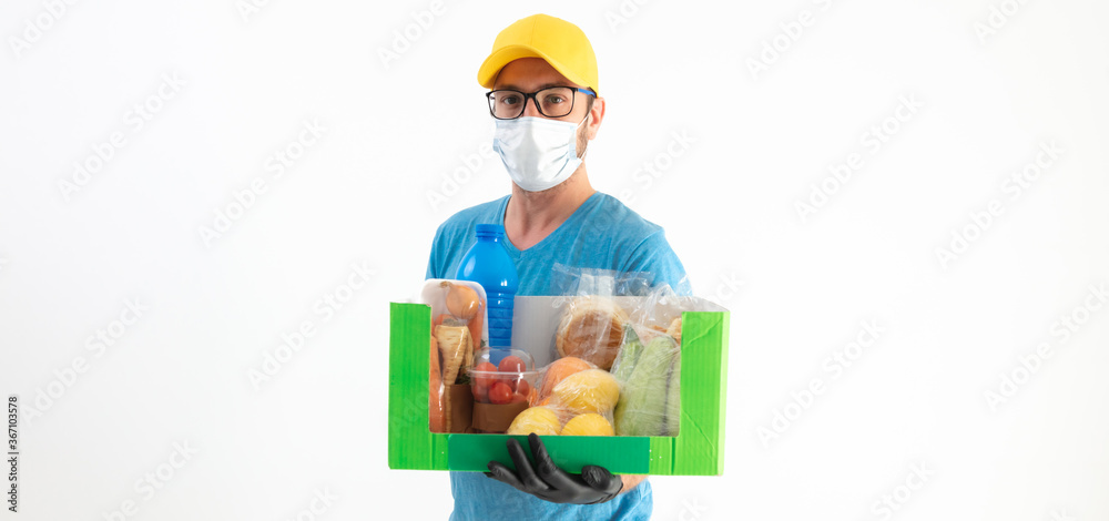 Delivery guy with protective mask holding box with groceries. Delivery guy with protective mask holding box with groceries.