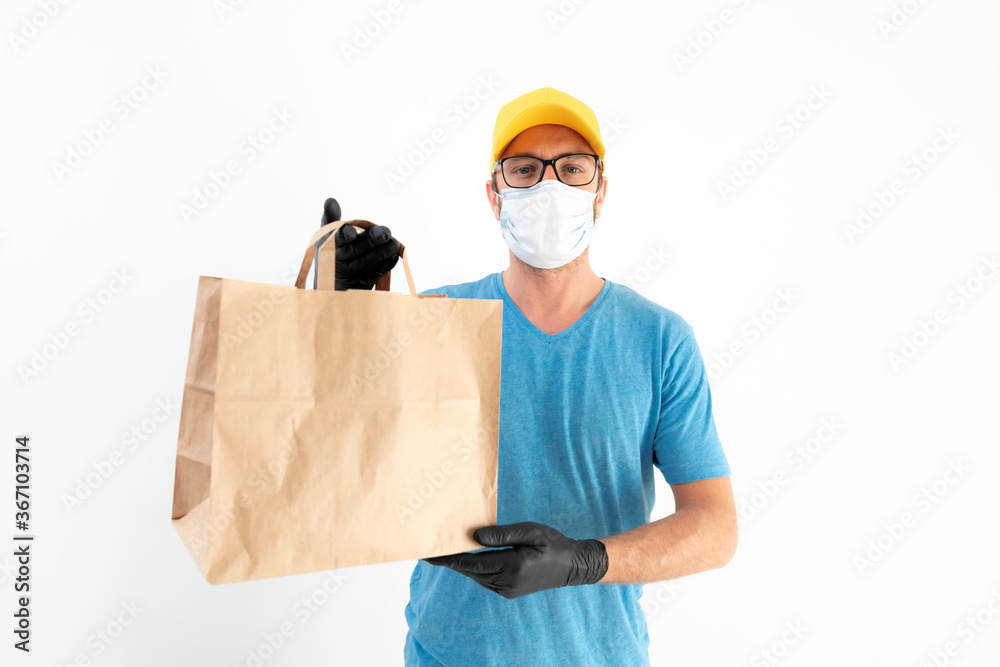 Delivery guy with protective mask holding paper bag with groceries. Delivery guy with protective mask holding paper bag with groceries.