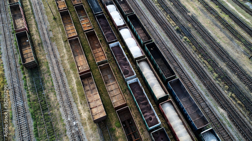 Aerial view of rail sorting freight station with railway cars, with many rail tracks railroad. Heavy industry landscape.