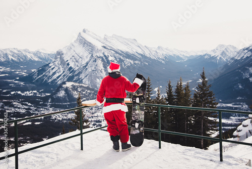 Photography Santa overlooking mountains with snowboard