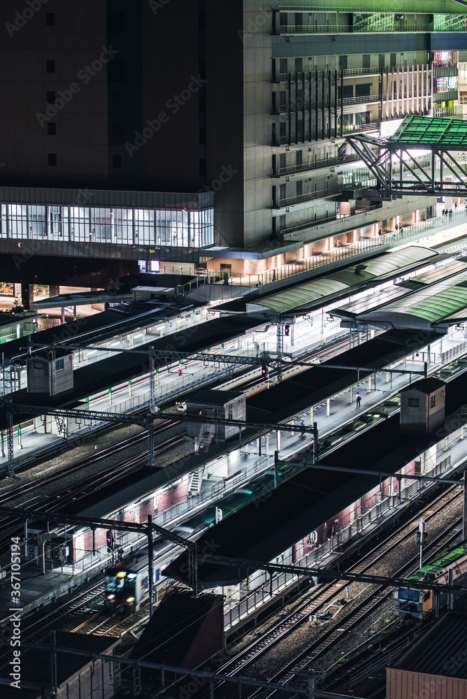 Fototapeta premium City train station with multiple platforms at night 