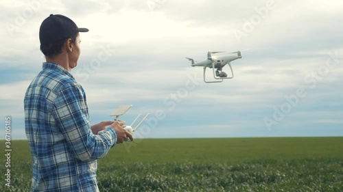Wallpaper Mural lifestyle smart farming tech agriculture farming. man farmer engineer studies a wheat crop in a green field using a technology quadcopter. male red worker neck works in a green field in a field of Torontodigital.ca