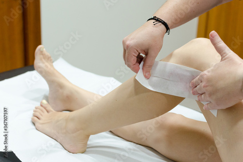 Slika na platnu Piernas de mujer a la que están depilando
