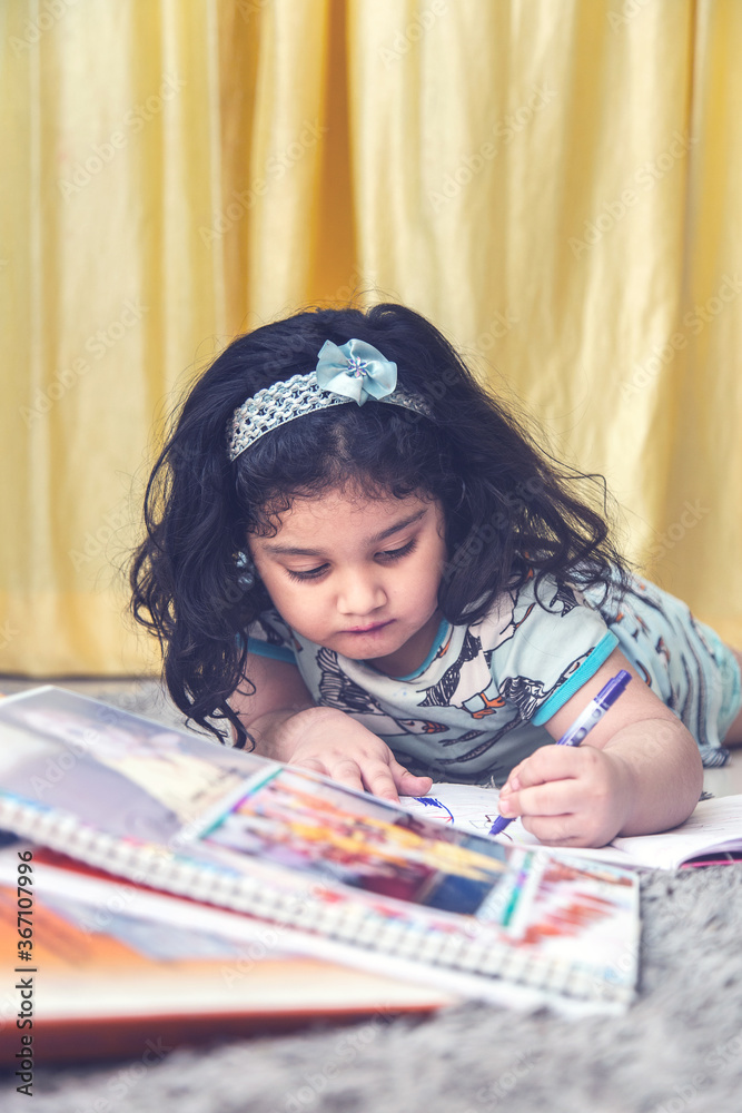 Indian Asian preschooler Schoolgirl With Pile Of Books studying online class at home. Indian Asian preschooler Schoolgirl With Pile Of Books studying online class at home.