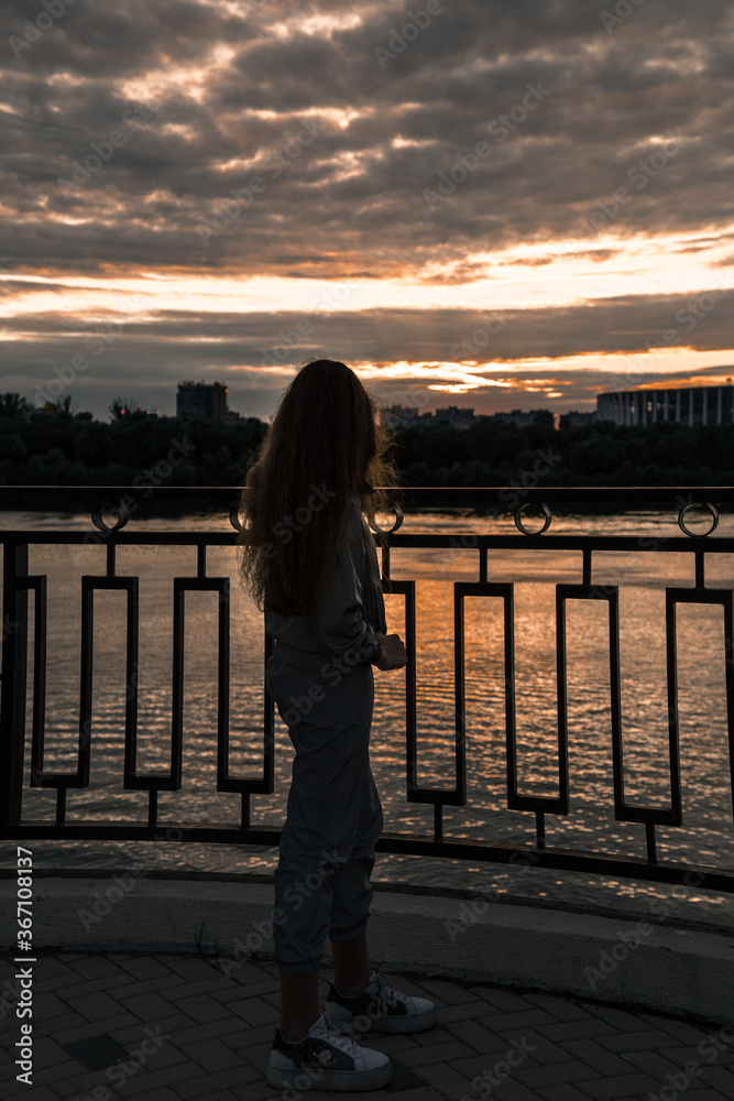 Fototapeta premium Femalе silhouette and sunset background