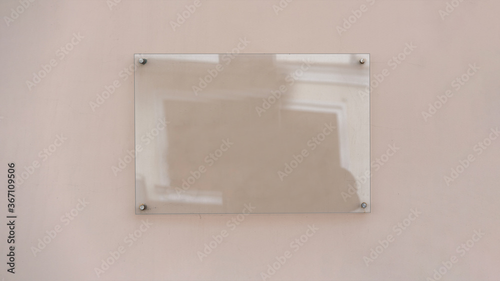 Transparent glass advertising signboard on concrete wall mock-up