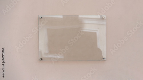 Transparent glass advertising signboard on concrete wall mock-up photo
