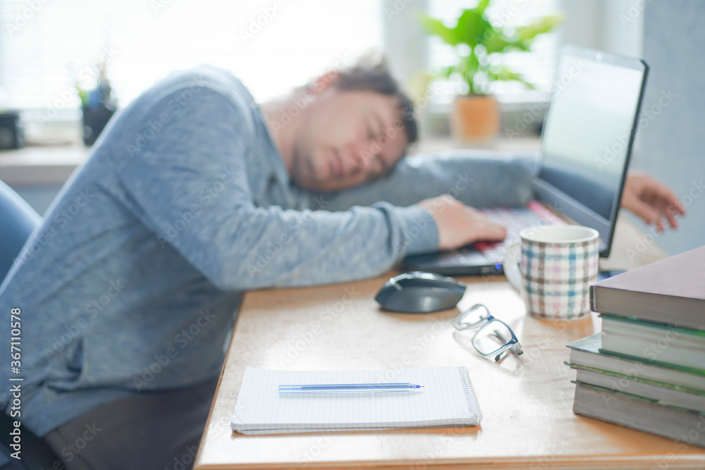 Tired of hard work student guy sleeping on laptop at table