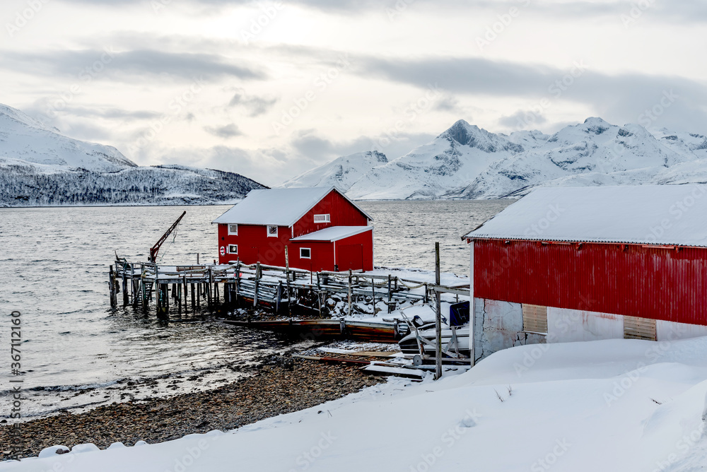 NORWAY, KVALOYA - MARCH 14, 2020 - winter atmospheric scenery with fishing pier in fjord Skulsfjord near Tromso