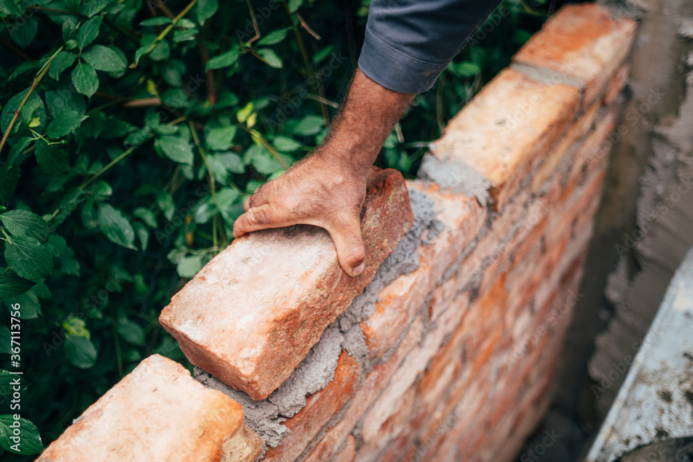 Close up of man, industrial bricklayer installing bricks on construction site. Close up of man, industrial bricklayer installing bricks on construction site.