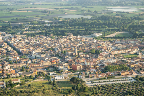 Aerial photo of a village with a church in the middle and surrounded by fields