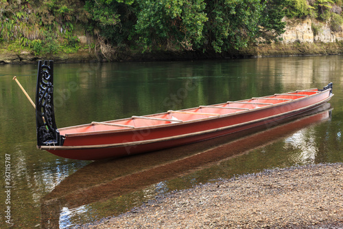 Fotografie A Maori waka (canoe) with ornamental carvings on the stern post in the Waikato R