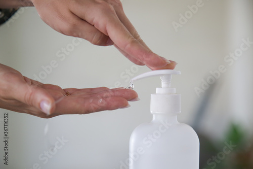 Woman applying hand sanitizer during Coronavirus and flu outbreak. Virus and illness protection. Hands disinfection as prevention of Coronavirus disease.	 photo