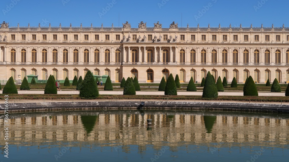 Château de Versailles vu du jardin, aile du Midi et son reflet dans l'eau du bassin du parterre du Midi (France)