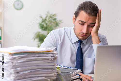 Young male businessman employee unhappy with excessive work