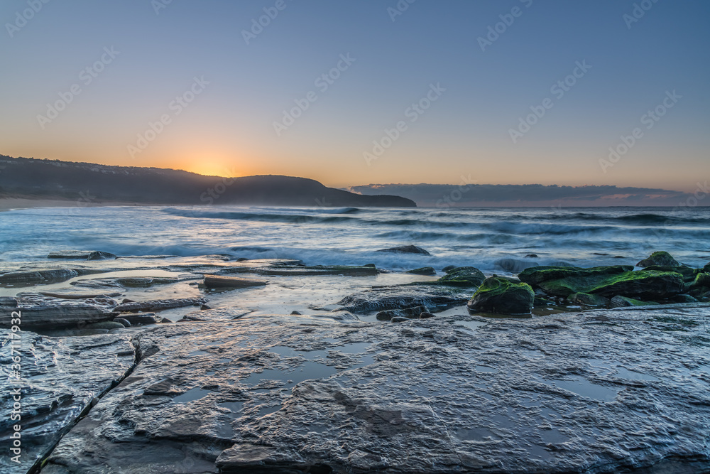 Clear skies winter sunrise seascape with fog on the horizon