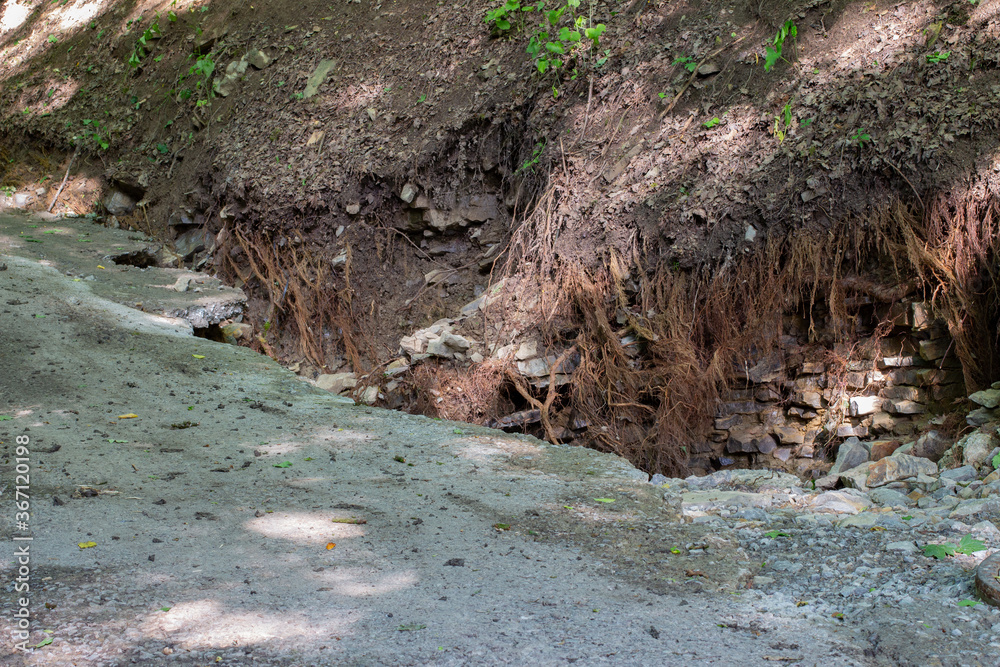 Road damage and destroyed blank roots after a flood Road damage and destroyed blank roots after a flood