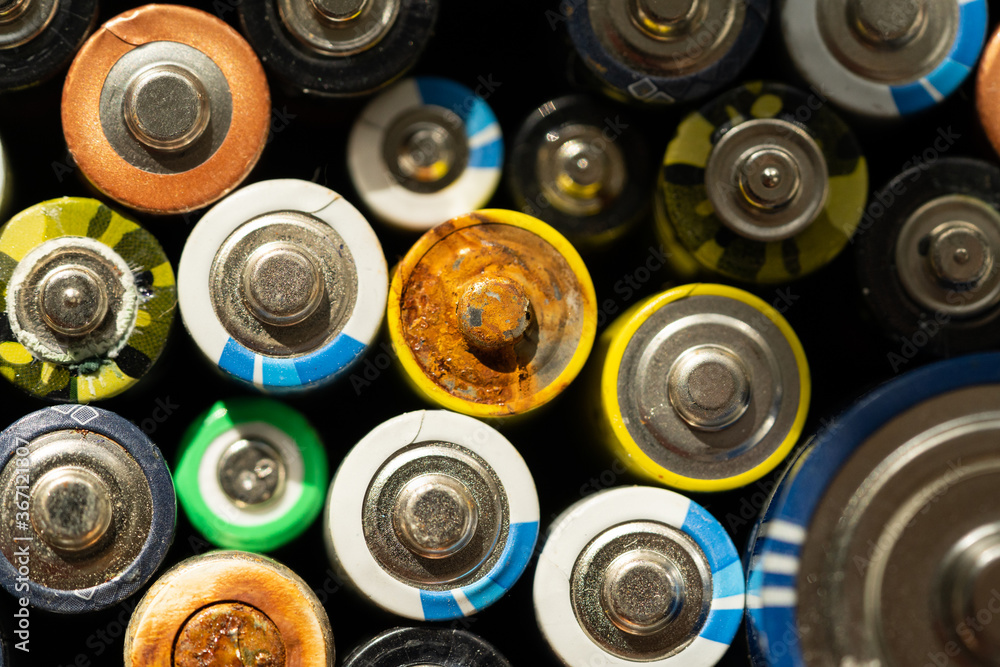 Close up of positive ends of discharged batteries of different sizes and formats, selective focus. Used battery with corrosion and rust. Hazardous garbage concept Close up of positive ends of discharged batteries of different sizes and formats, selective focus. Used battery with corrosion and rust. Hazardous garbage concept