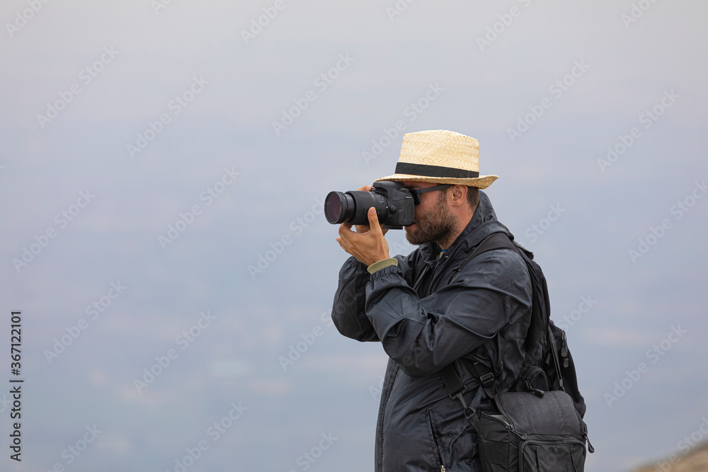 A young man enjoys taking photos in nature on his way to the cold summit of Moncayo, the highest mountain in the Iberian System, in the Tarazona region of Aragon, Spain.