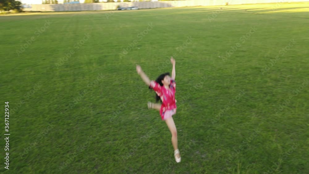 Japanese ballerina jumps and performs gymnastic twine on lawn. Japanese ballerina jumps and performs gymnastic twine on lawn.