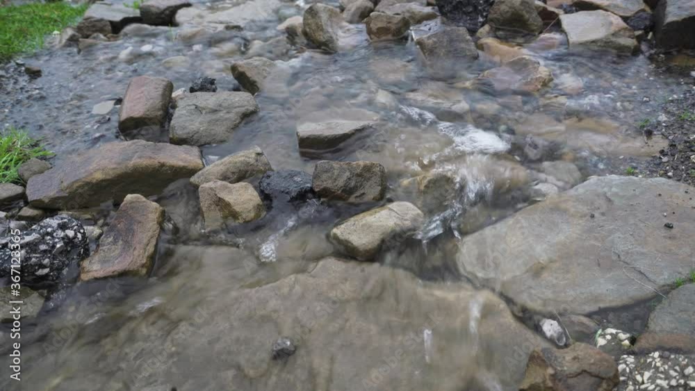 Running stream water background over rocks and pebbles Running stream water background over rocks and pebbles