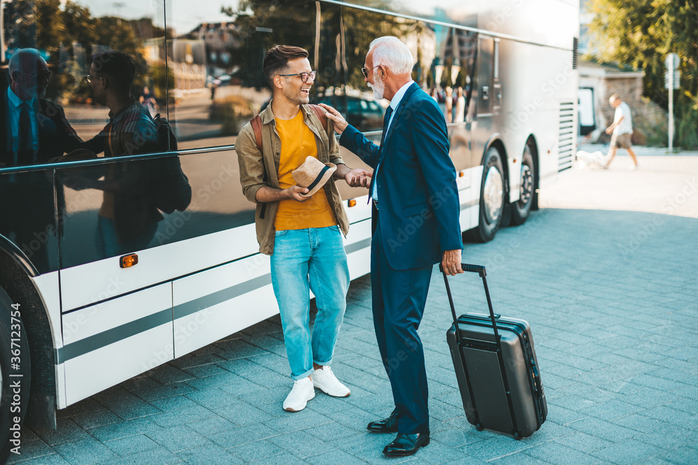 Obraz premium The bus driver accepts luggage from passenger.