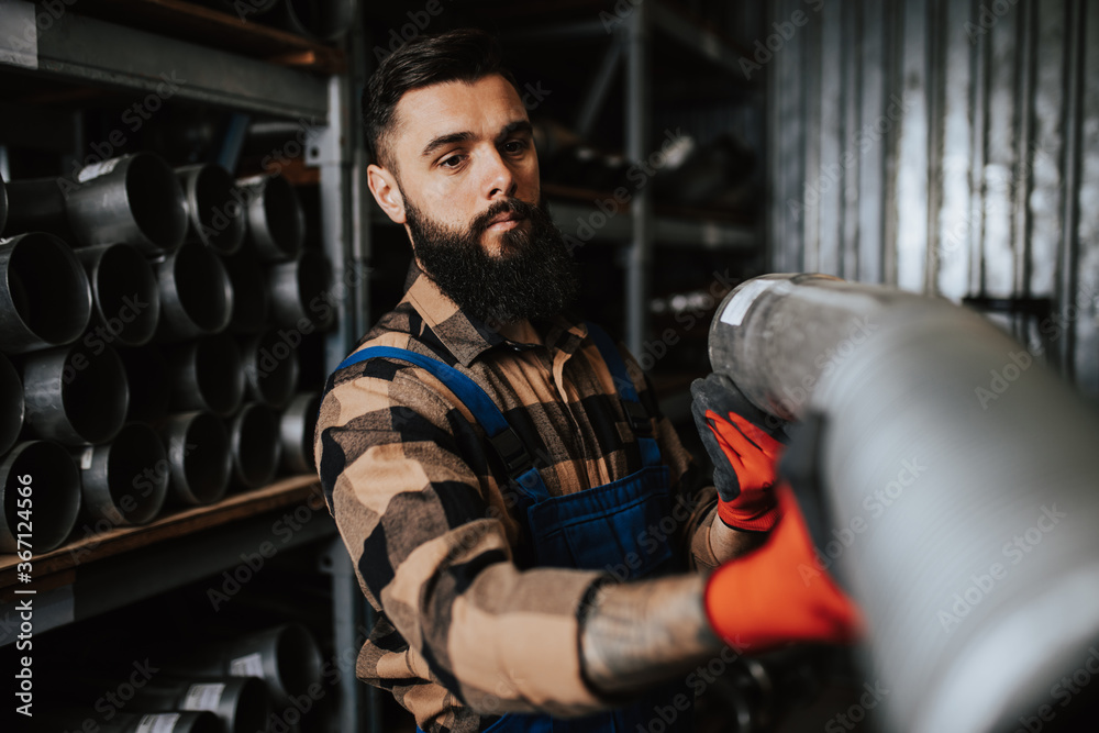 Handsome adult man working in car and truck spare parts warehouse. Handsome adult man working in car and truck spare parts warehouse.