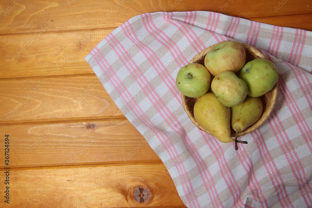 frail of apples and pears on a towel on wooden table flat lay