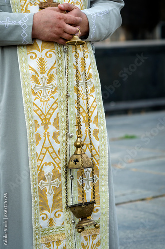 Big hanging lamp in the hands of orthodox priest