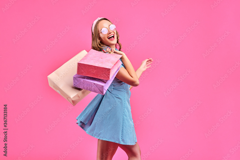 Shopping woman happy smiling holding shopping bags isolated on pink background. Shopping woman happy smiling holding shopping bags isolated on pink background.