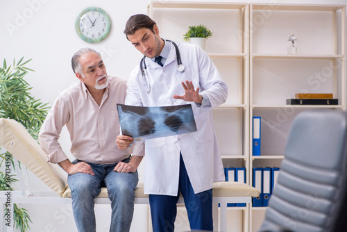 фотографія Young male doctor and old patient in antismoking concept